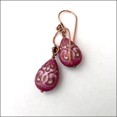 Intricately patterned acrylic drops in a beautiful magenta colour etched with copper. They hang on ornate copper earwires