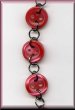 tiny pearly raspberry red button necklace fastens with a black plated lobster clasp